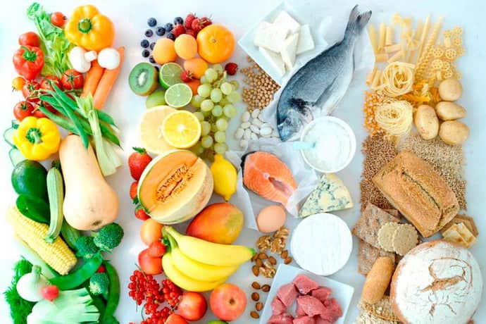 Разложенные по категориям фрукты, овощи, рыба, молочные продукты, мясо и злаки, вид сверху, яркие цвета